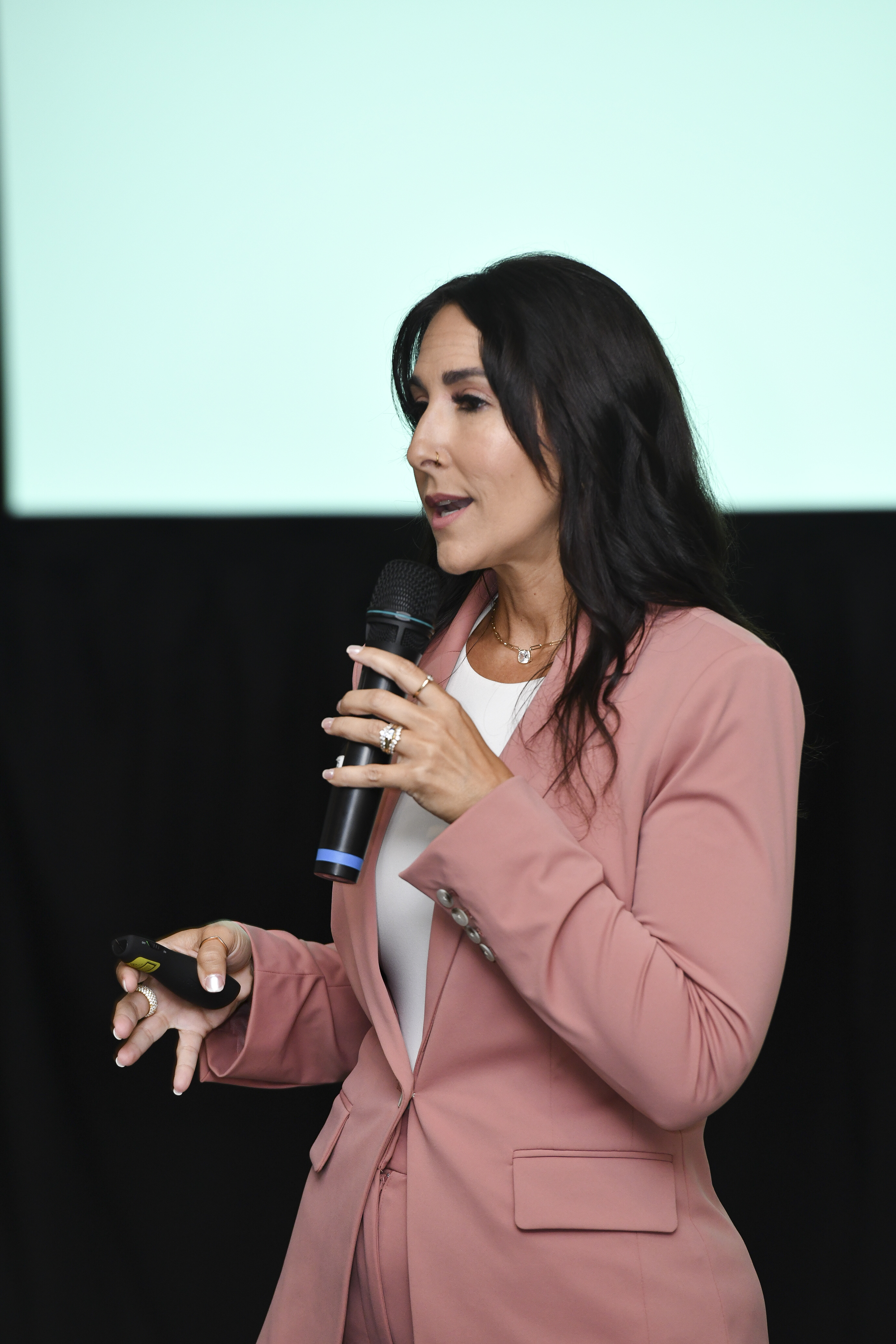 Mandy Reed speaking with a microphone and presentation remote